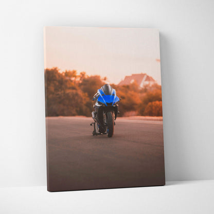 Vertical canvas wall art featuring a blue Yamaha R1 motorcycle on a sunset road with warm orange trees and hills background.
