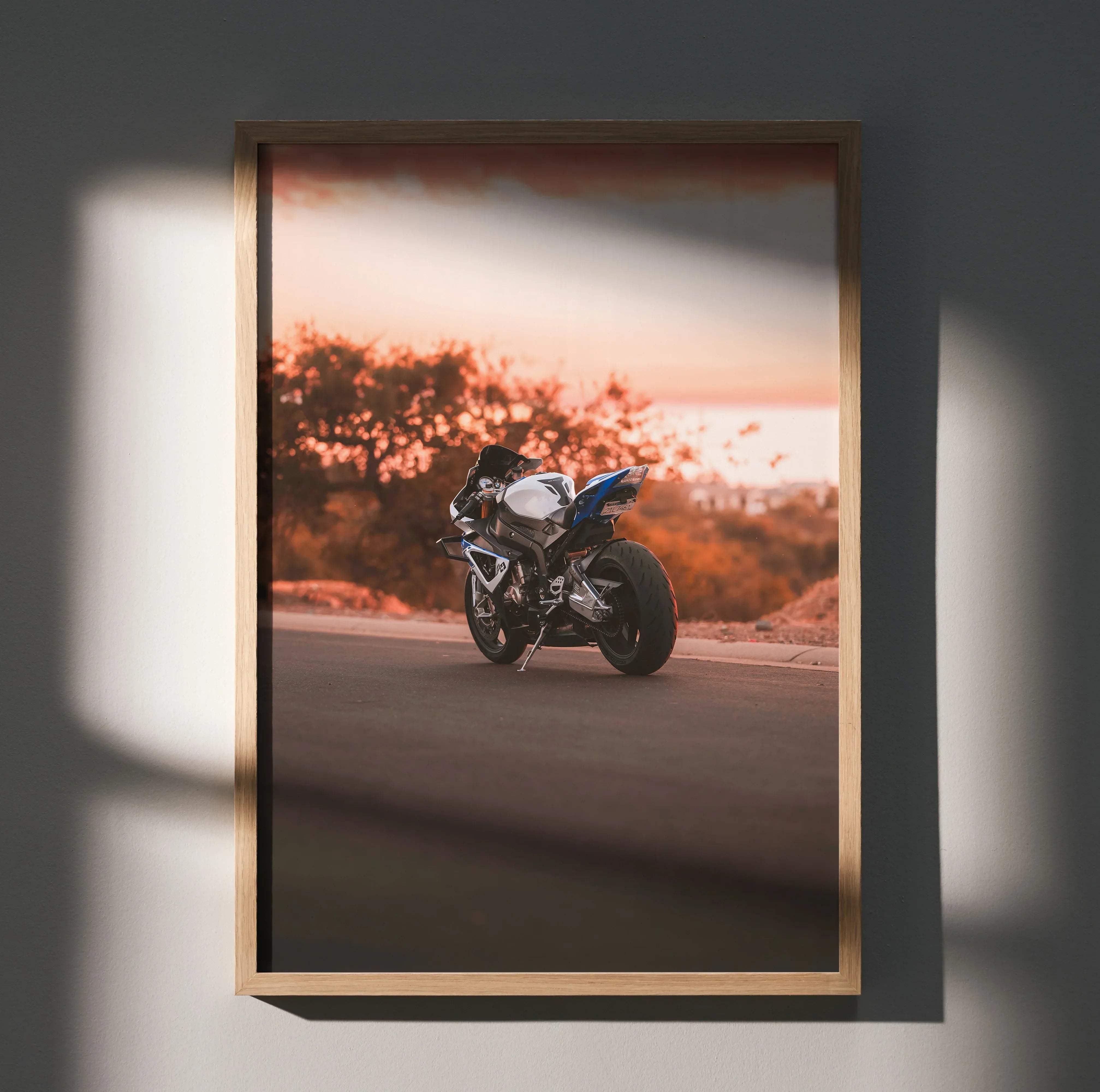 A framed BMW inspired S1000RR HP4 motorcycle art poster featuring a white and blue sport bike at sunset