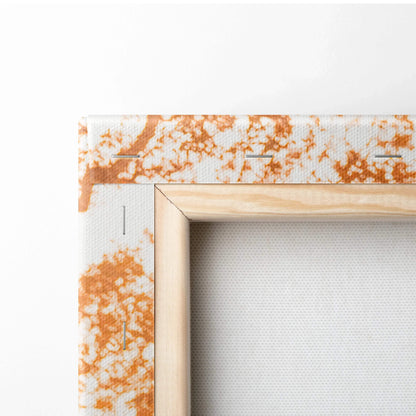 Close-up of wooden frame corner with white canvas and orange textured pattern wall art.