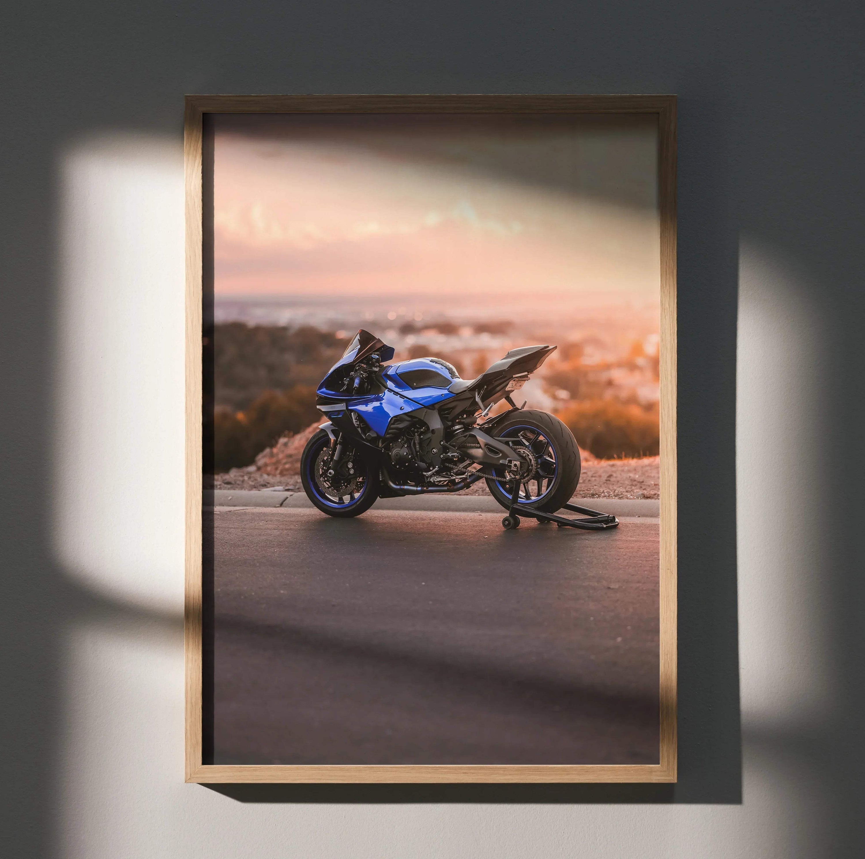 Yamaha R1 motorcycle poster with blue and black bike against sunset wall art in wooden frame.