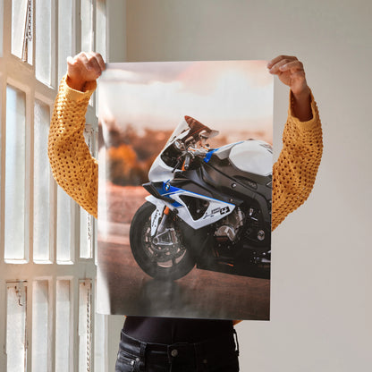 BMW S1000RR HP4 motorcycle poster wall art held by person near window with golden hour lighting.