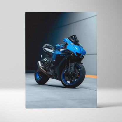 Vertical canvas art of a blue Yamaha R1 motorcycle against dark wall background.