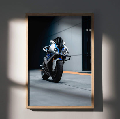 A framed photograph of a white and blue bmw s1000rr hp4 sport motorcycle with black accents in a minimalist wooden frame