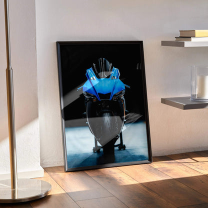 Yamaha R1 motorcycle poster with bold blue and black design leaning on wood floor wall art.