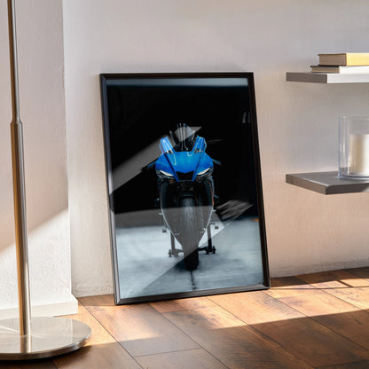 Yamaha R1 motorcycle poster in blue and white on black background, premium satin wall art framed and leaning on wooden floor.