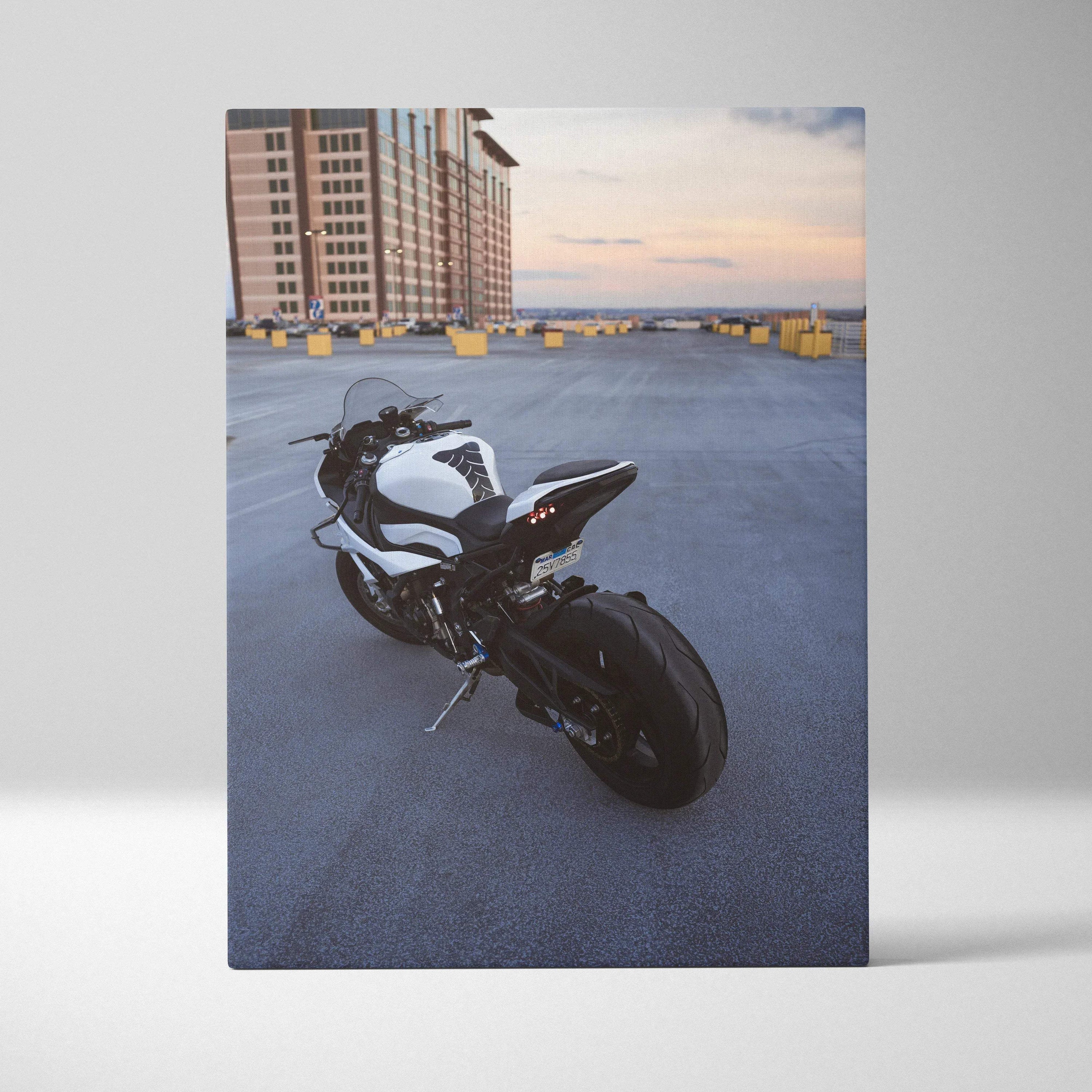 Vertical canvas wall art of a white and black BMW S1000RR motorcycle parked on rooftop at sunset.