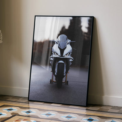 BMW S1000RR motorcycle front view poster wall art in black frame leaning on floor.