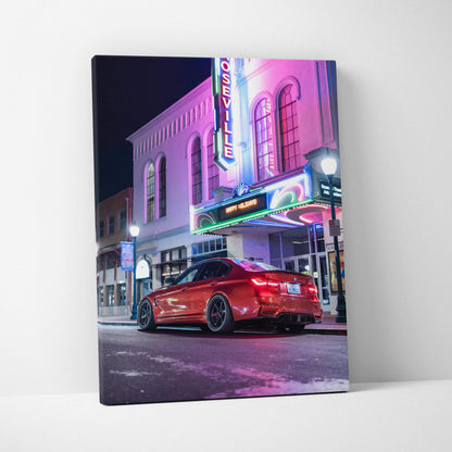Vertical canvas wall art featuring a red BMW F80 M3 parked under neon lights at night.