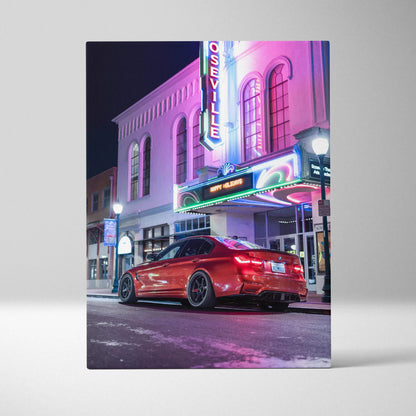 Vertical canvas art featuring a red BMW F80 M3 parked under neon-lit Seville theater sign at night.