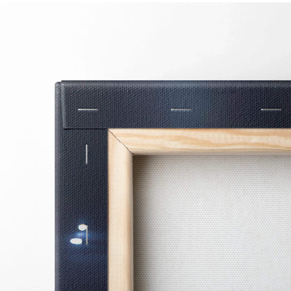 Close-up of wooden stretcher frame supporting black canvas wall art with visible staples and corner joint details.