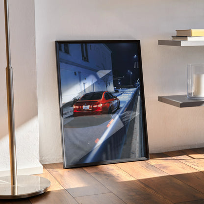 BMW F80 M3 poster showing rear view of red car on city street at night, sleek automotive wall art in black frame.