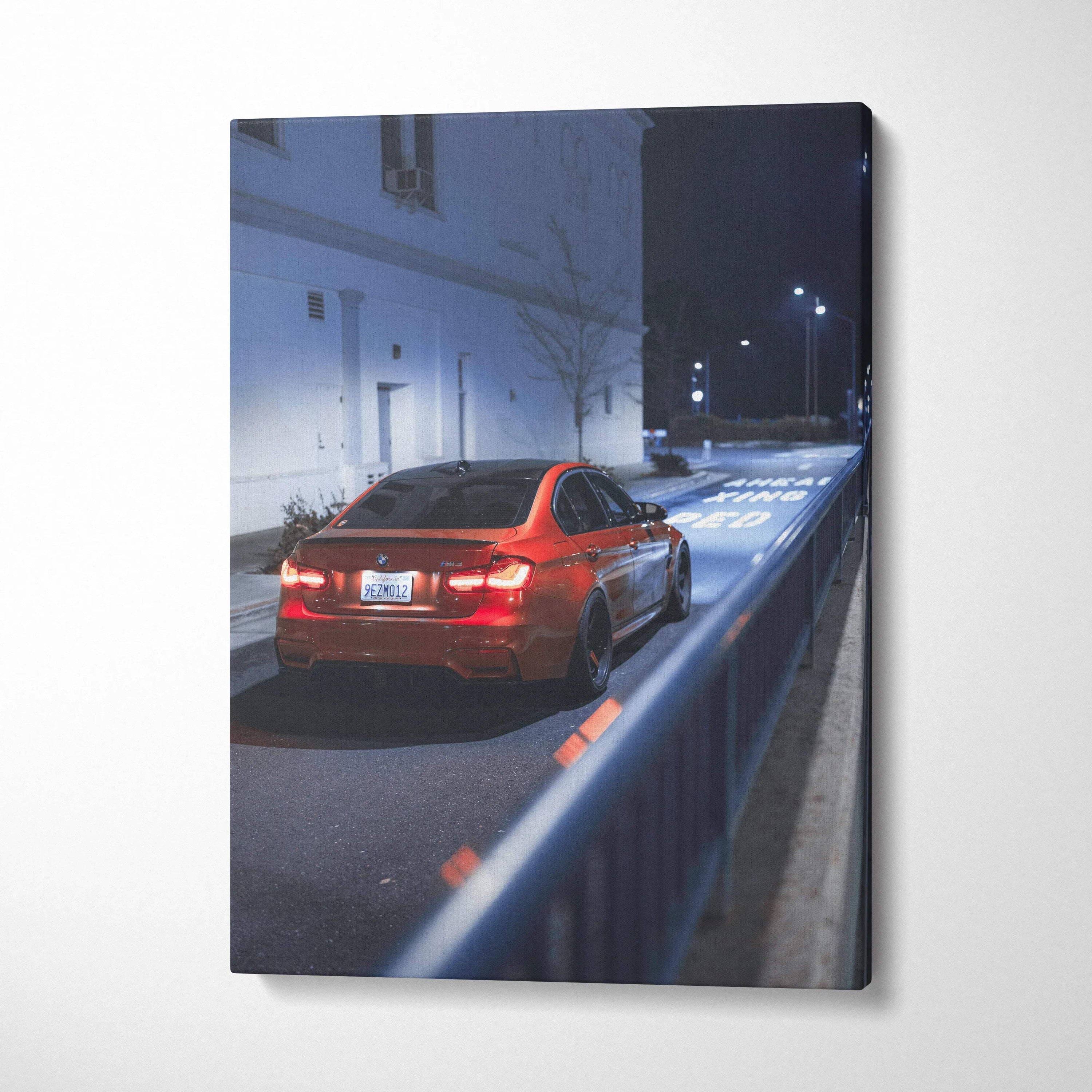 Vertical canvas art of a red BMW F80 M3 parked on a dimly lit urban street at night, wall art with high-resolution detail.