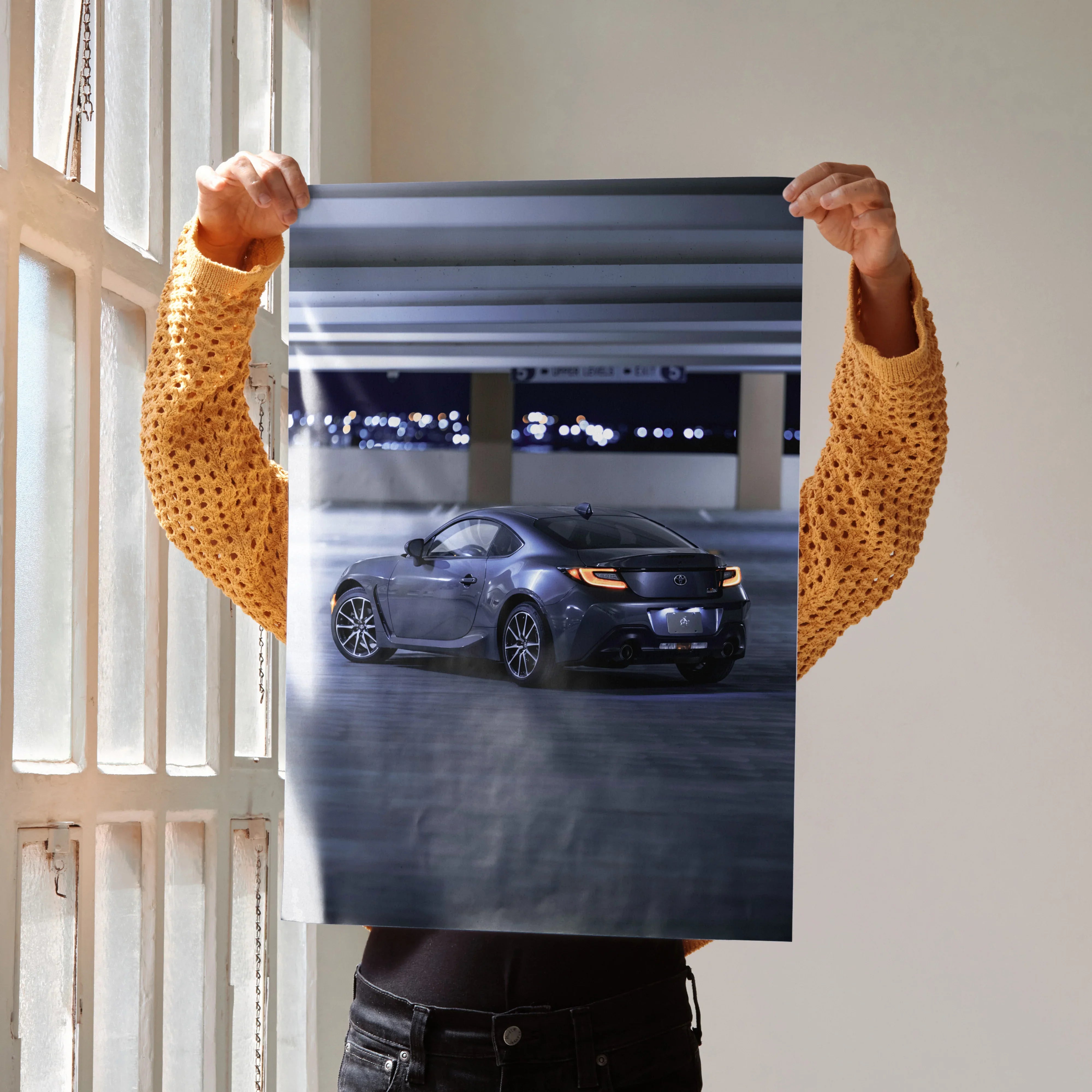 Toyota GR86 poster featuring sleek dark gray sports car under stadium lights, wall art for automotive fans.