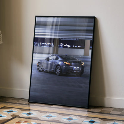 Toyota GR86 sleek sports car in dark garage setting poster wall art in black frame.