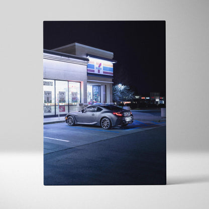 Toyota GR86 parked at night outside a lit building, vertical canvas wall art print.