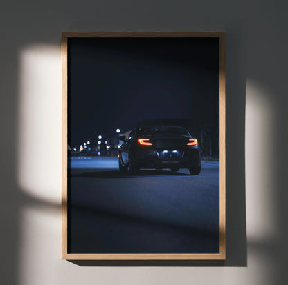 Toyota GR86 wall art poster showing rear view of a car at night in a wooden frame.