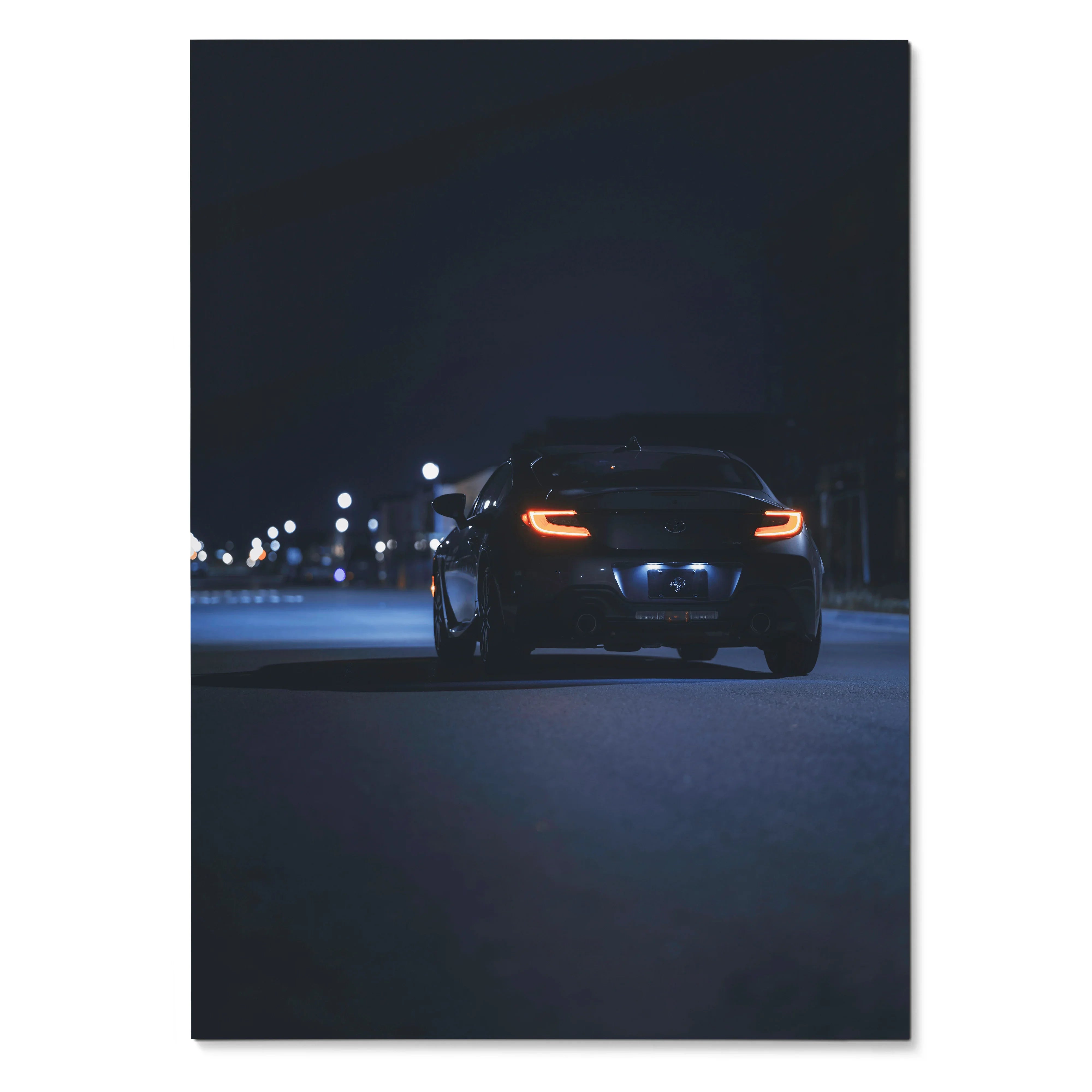 Toyota GR86 poster showing rear view of black car with illuminated tail lights at night, wall art for automotive decor.
