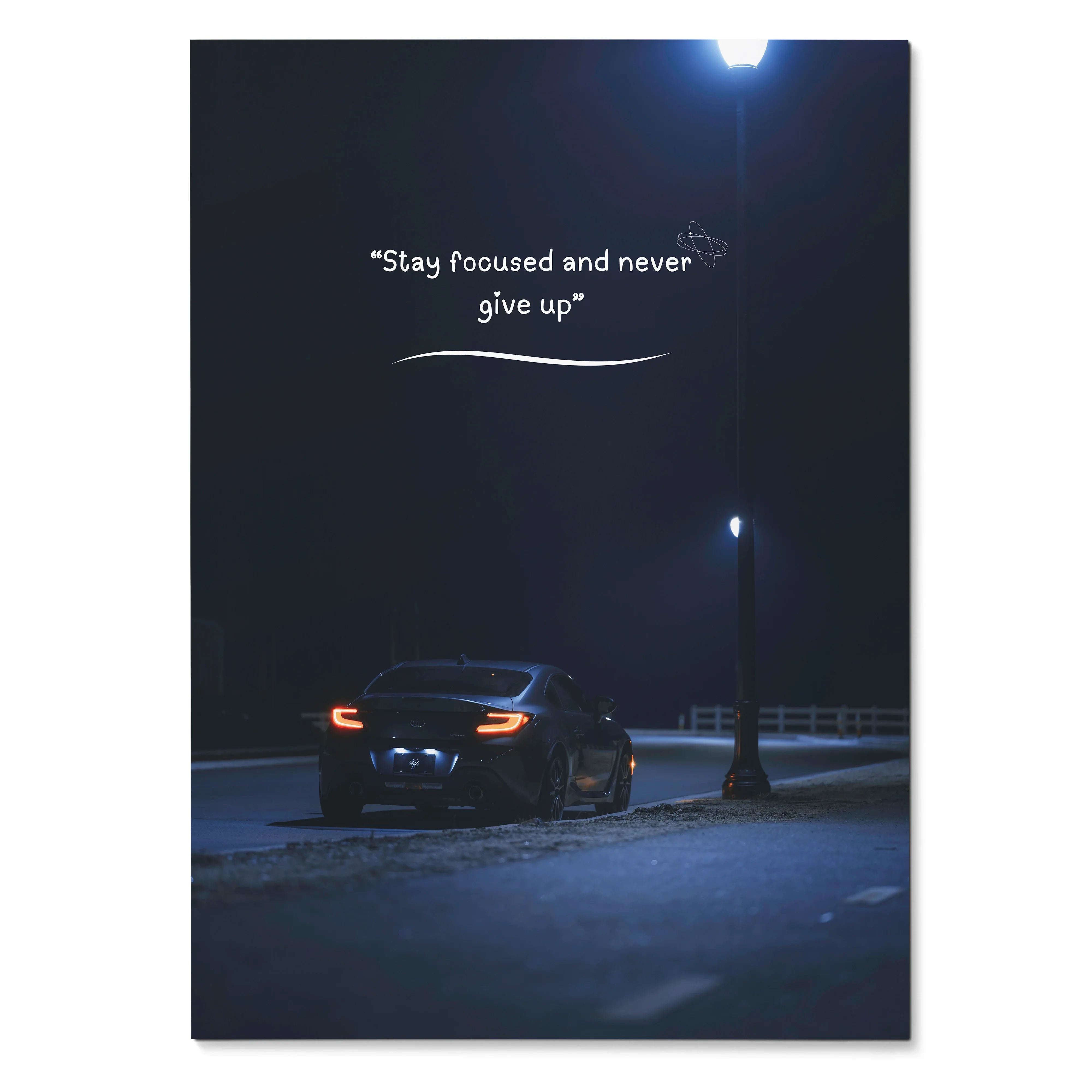 Motivational poster wall art with a Toyota GR86 under streetlights and inspiring text "Stay focused and never give up".