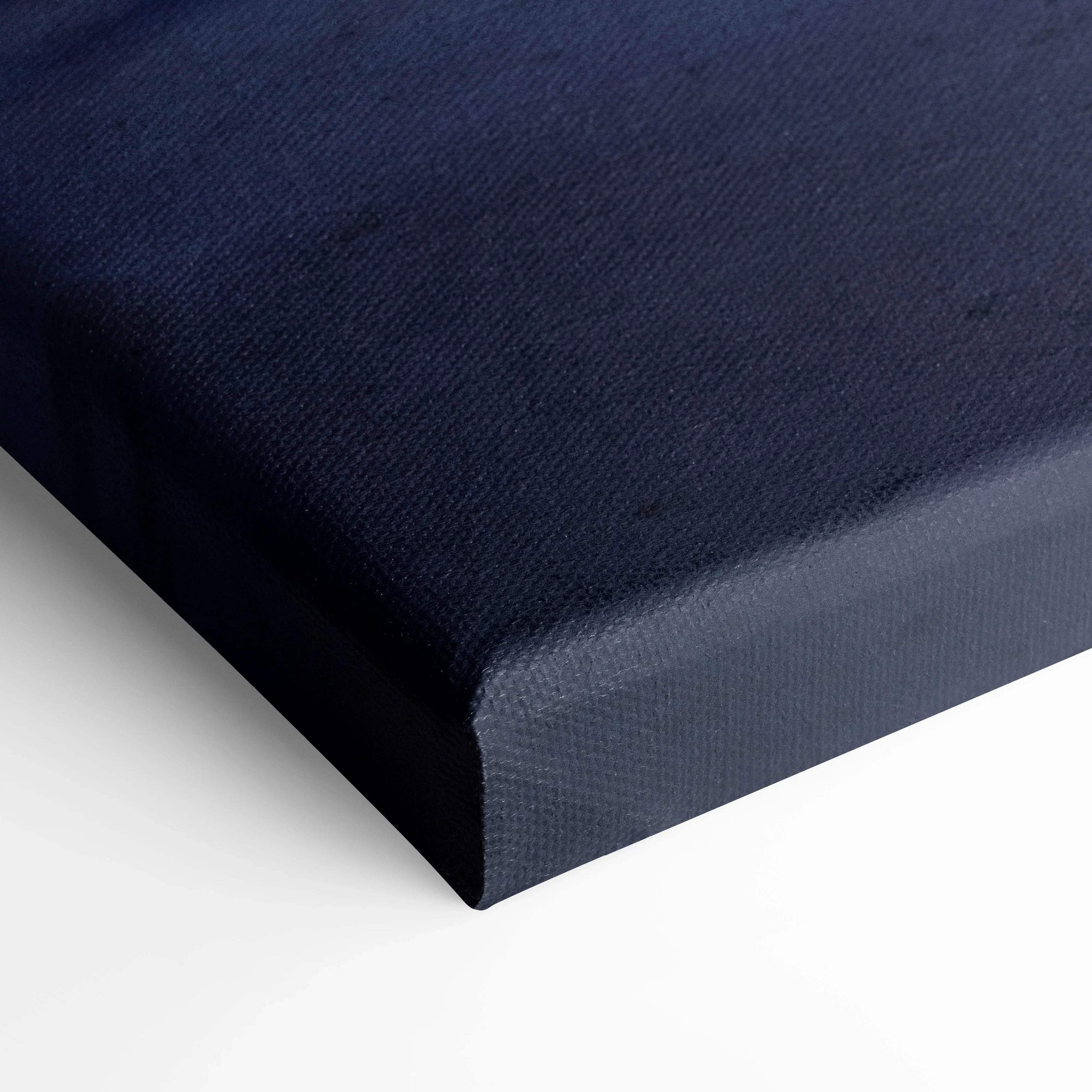 Close-up of navy blue textured canvas wrapped around wooden frame for wall art or canvas art display.