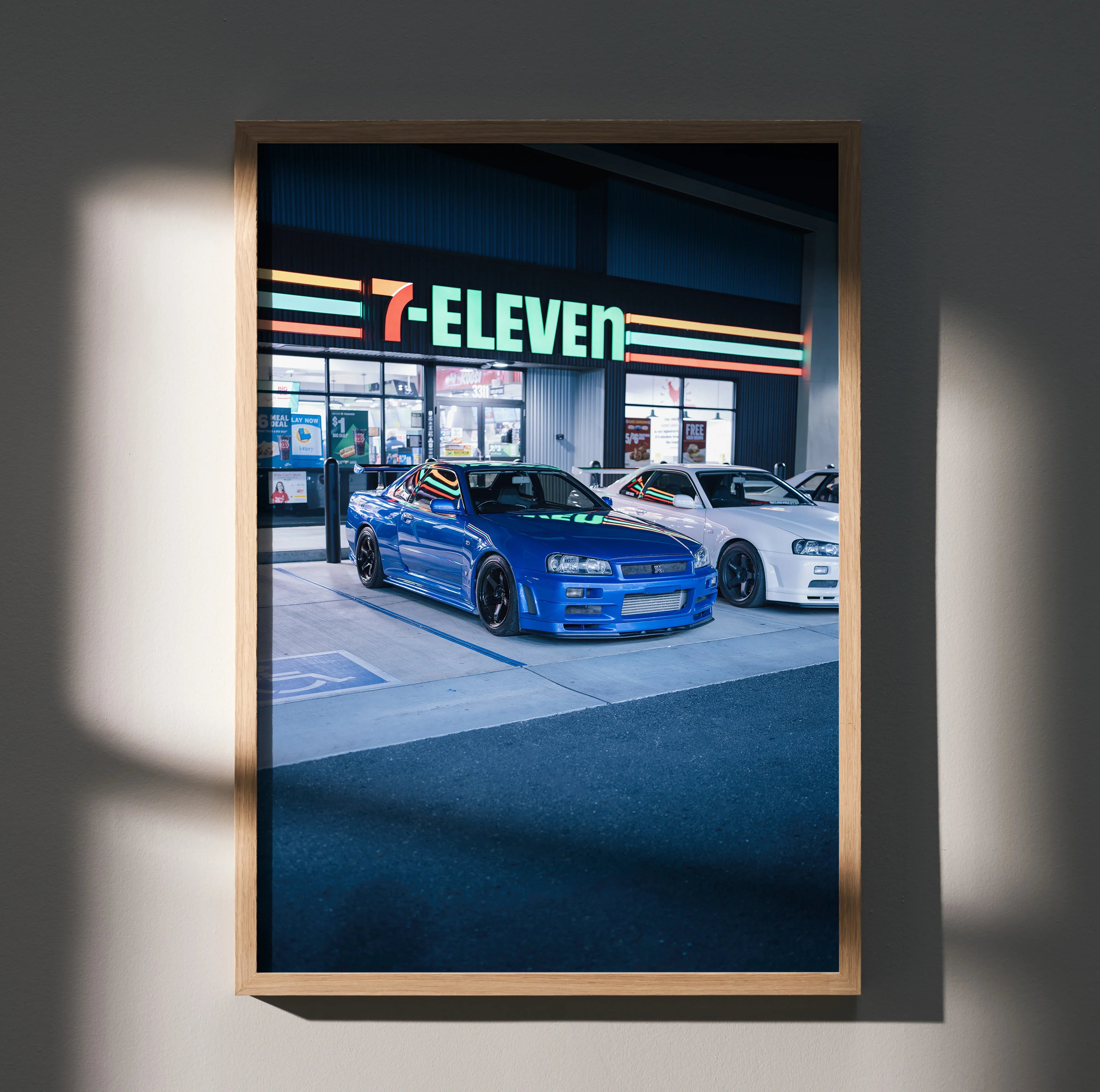 Nissan R34 GTR in blue parked outside 7-Eleven at night poster wall art.