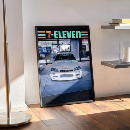 Nissan R34 GTR poster with 7-Eleven storefront in background, framed wall art in modern room setting.