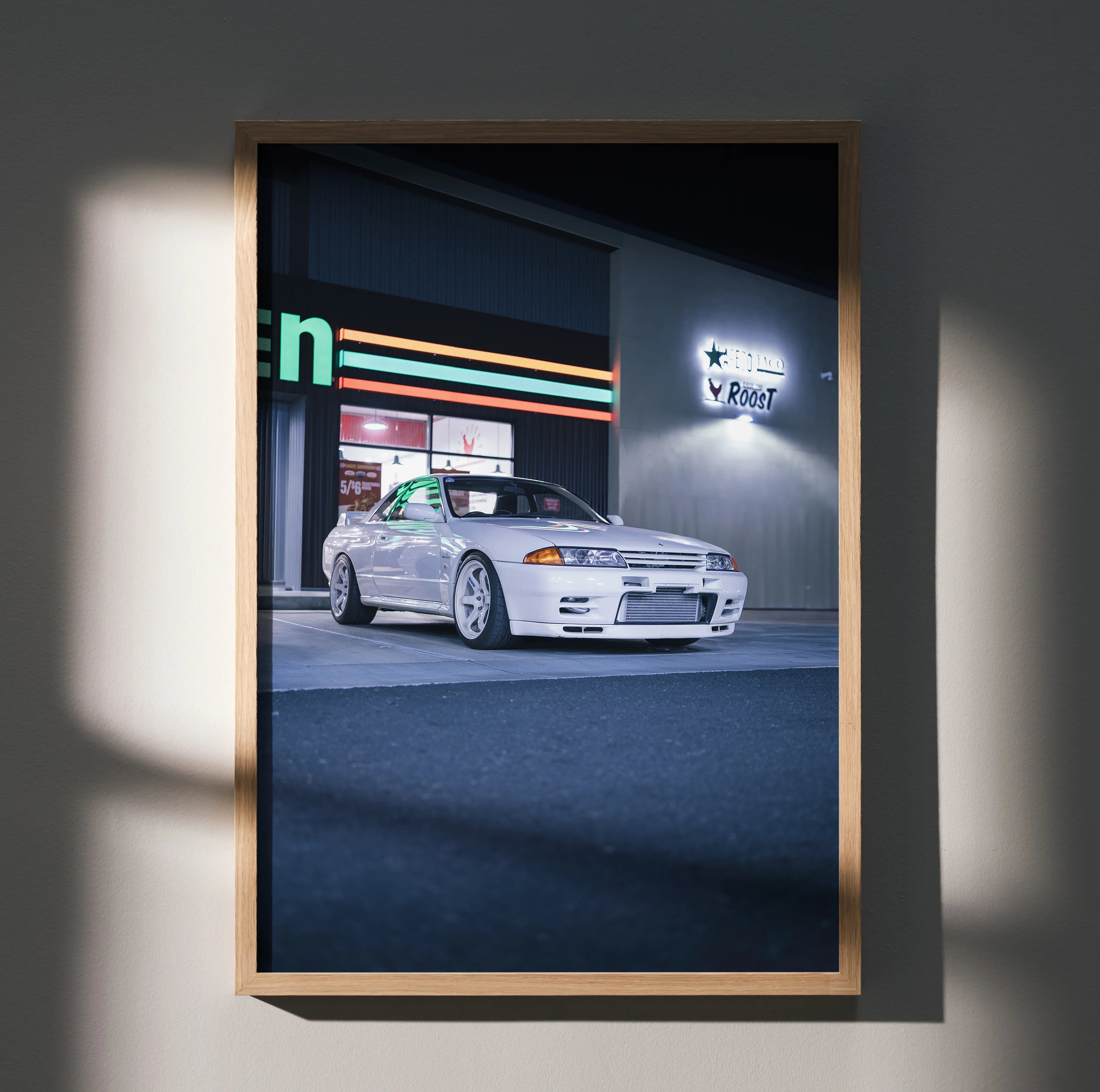 Nissan R32 GTR sports car poster wall art with nighttime cityscape background in wooden frame.