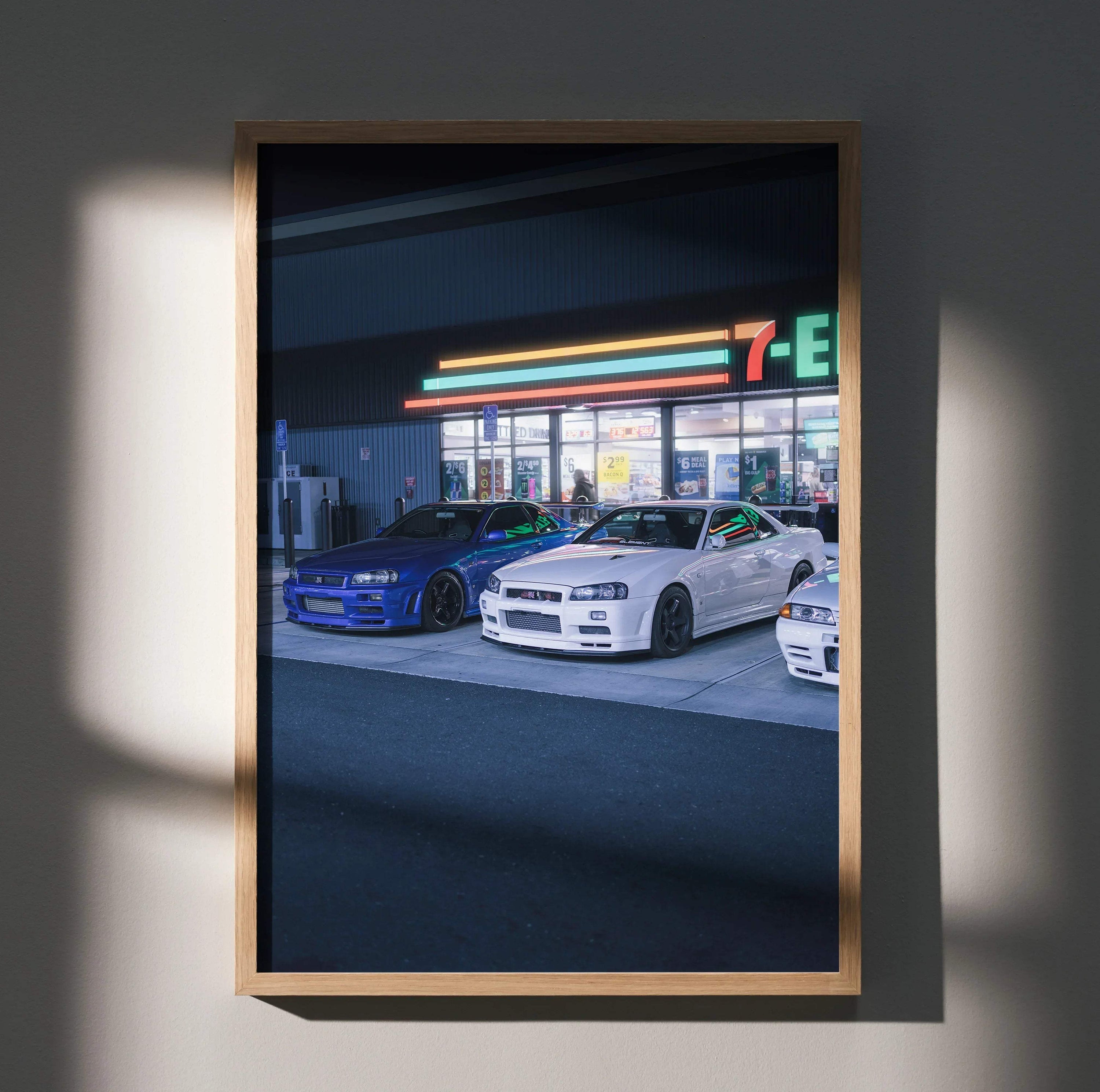 Nissan GTR R34 Skyline poster featuring blue and white cars in front of a 7-Eleven at night wall art.