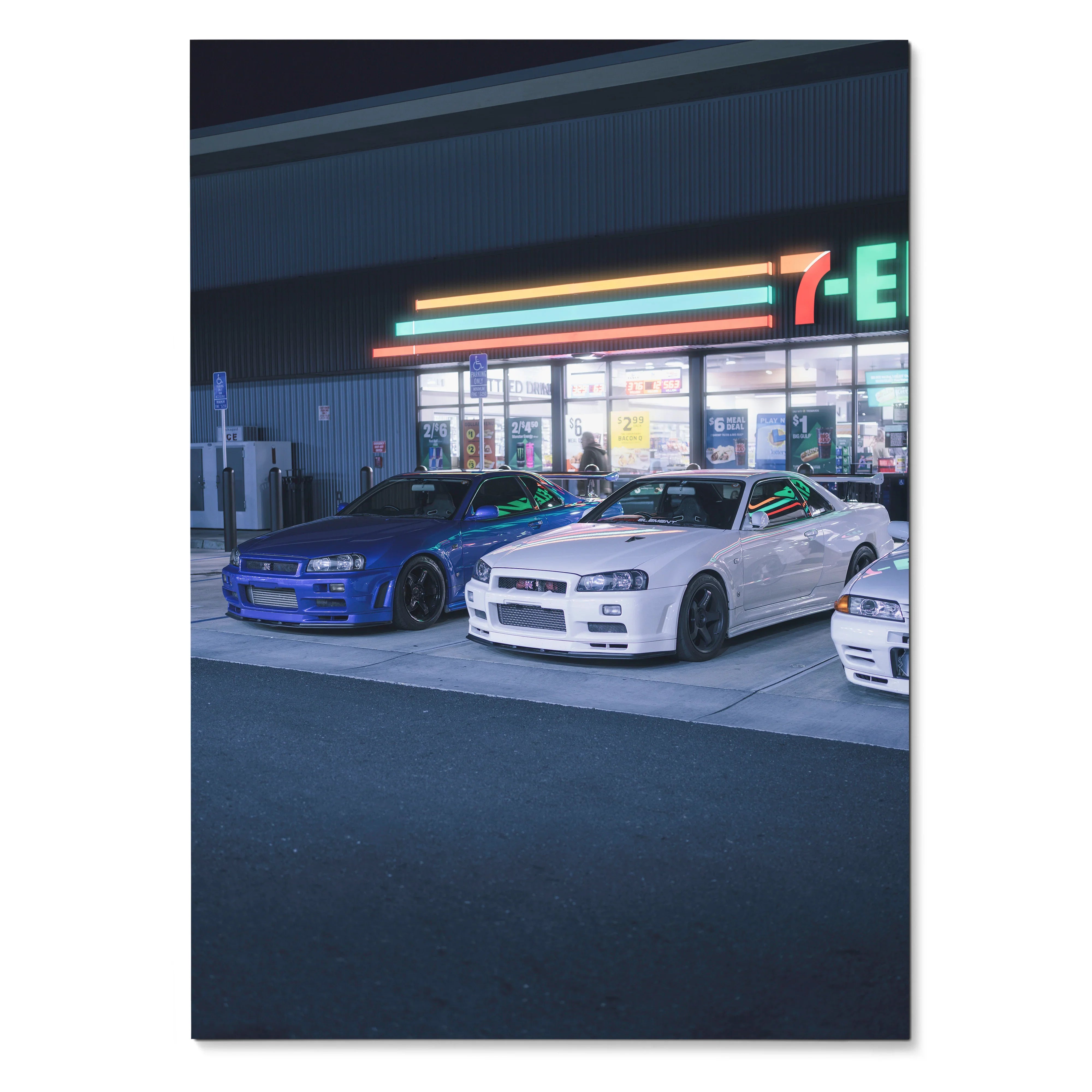 Nissan GTR R34 Skyline poster featuring blue and white cars parked outside a neon-lit 7-Eleven at night wall art.