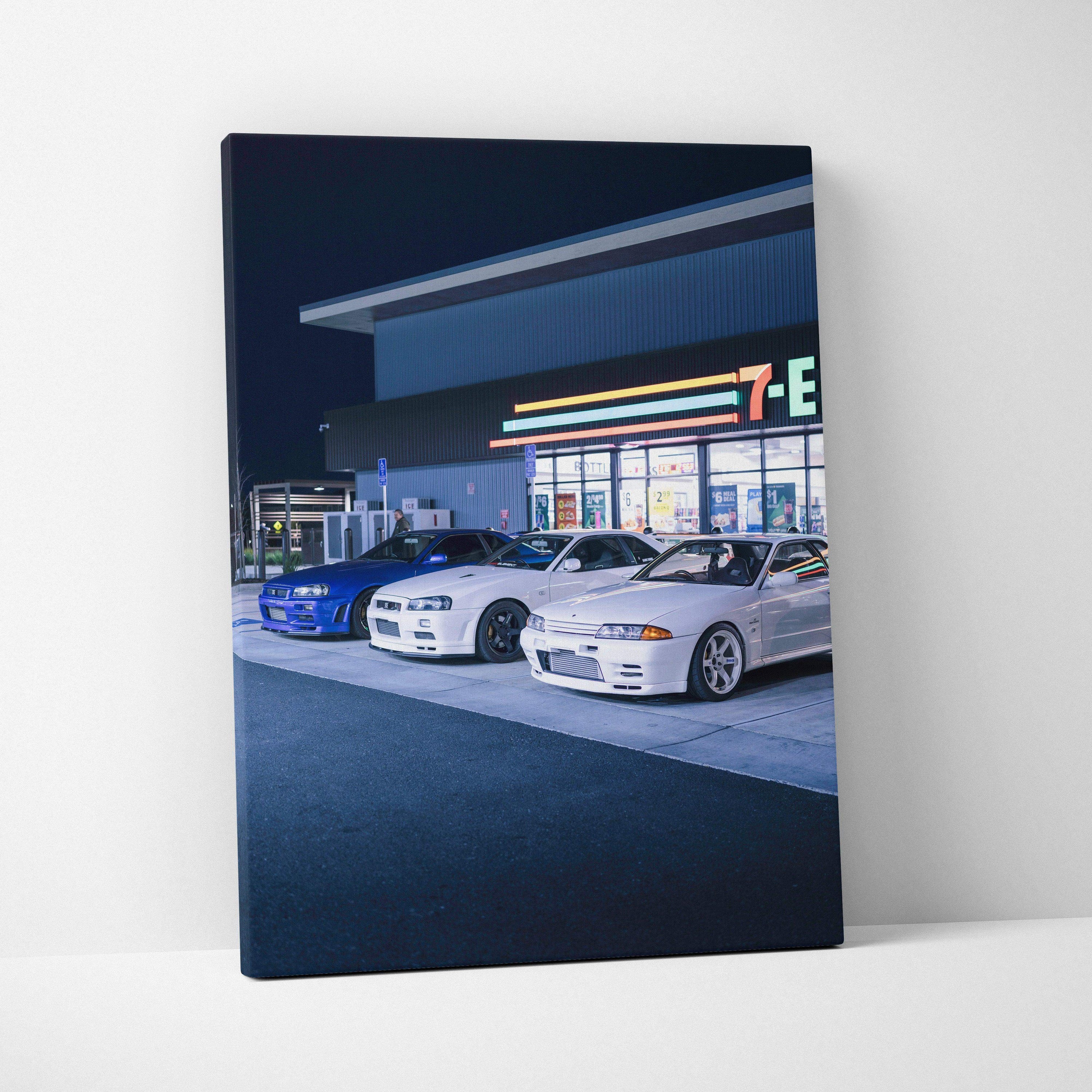 Vertical canvas wall art featuring Nissan GTR R34 Skyline cars parked at night outside a convenience store.