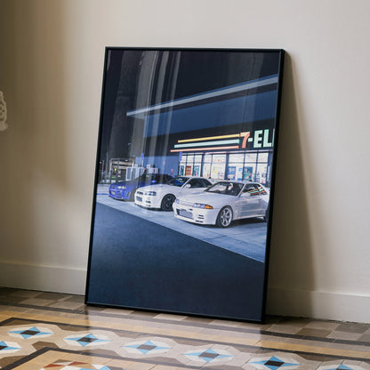 Nissan R32 and R34 GTR Skyline poster showcasing two white cars in front of a gas station at night wall art.