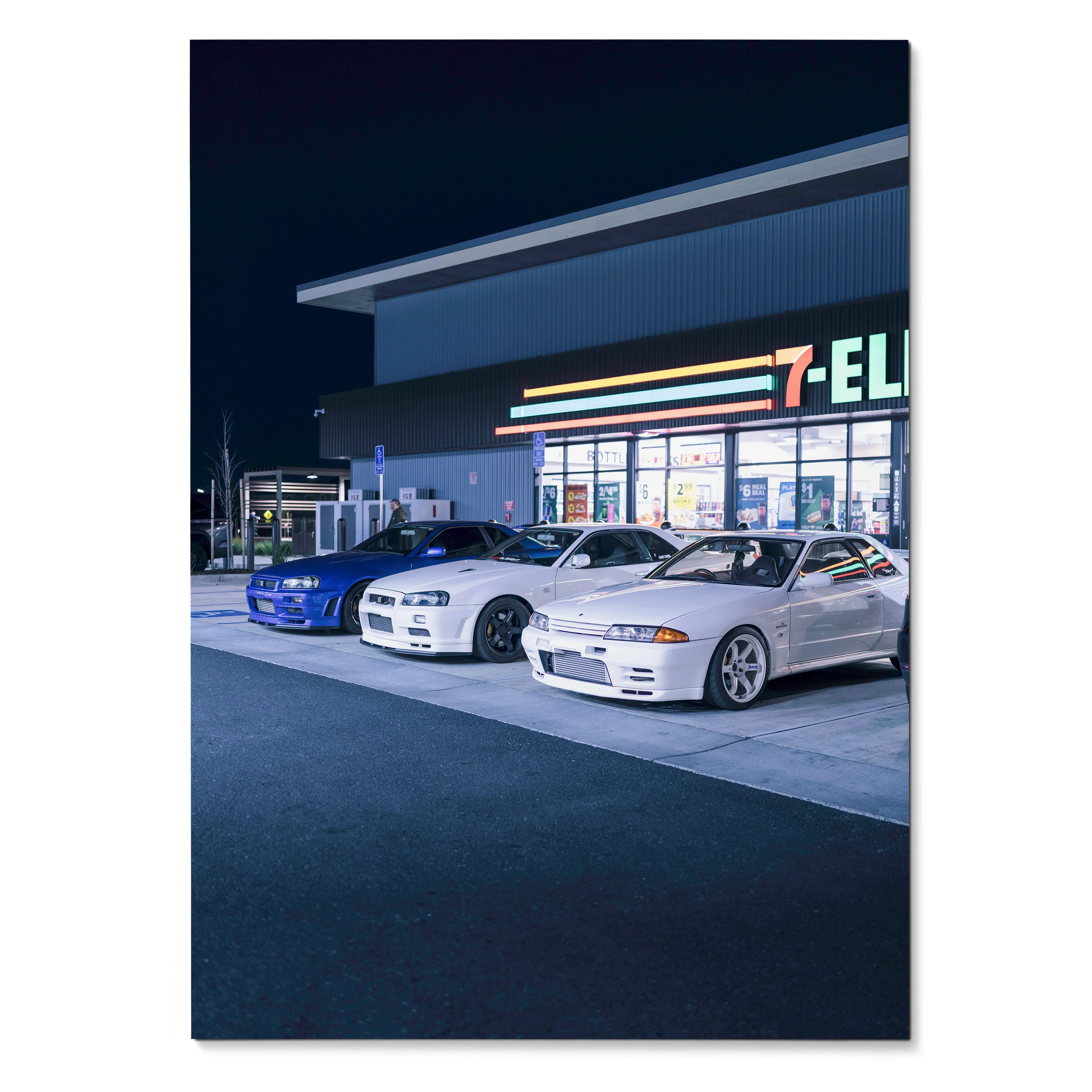 Poster wall art featuring Nissan R32 and R34 GTR Skyline cars parked outside a 7-Eleven at night.