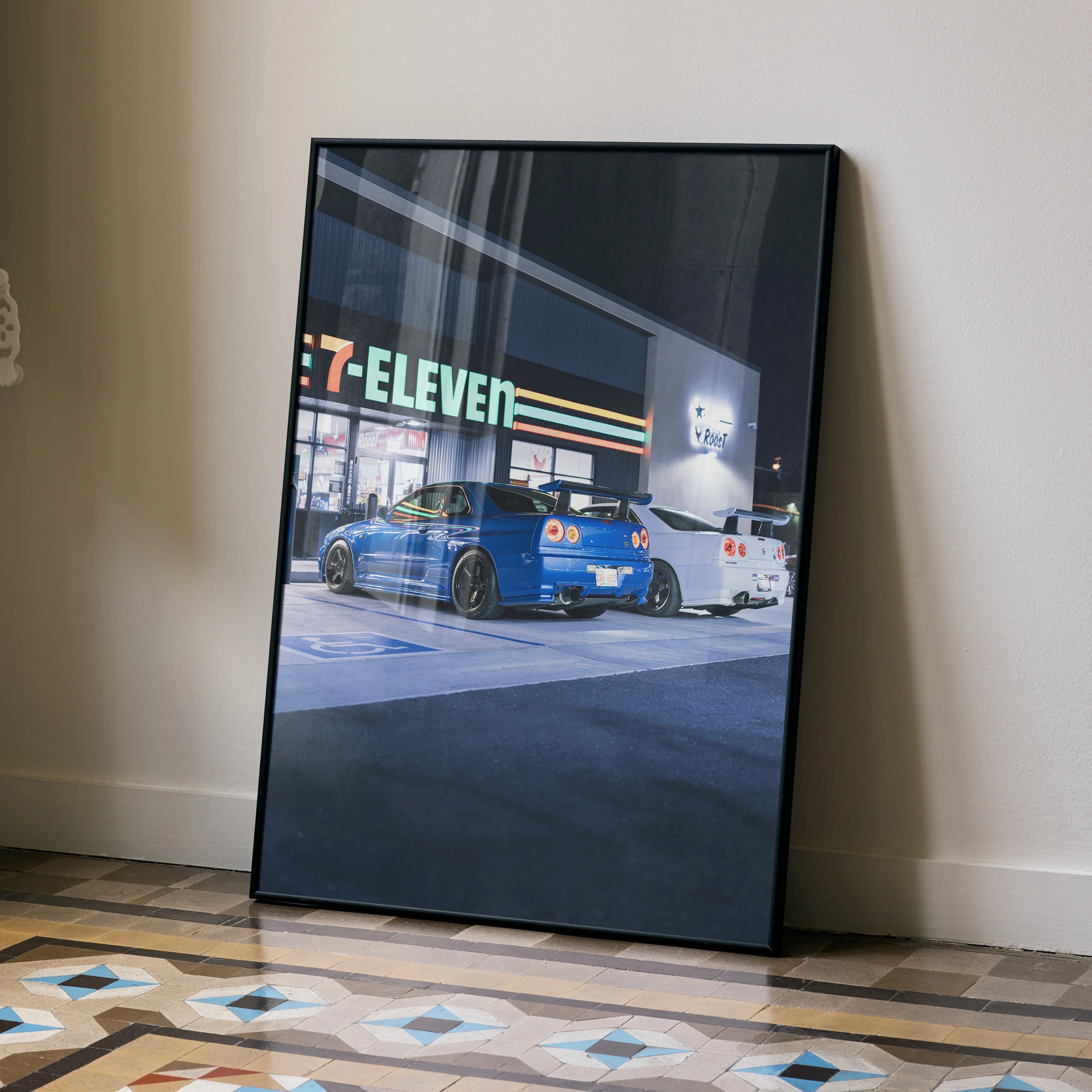 Nissan GTR R34 Skyline parked at night outside 7-Eleven, automotive poster wall art in black frame.