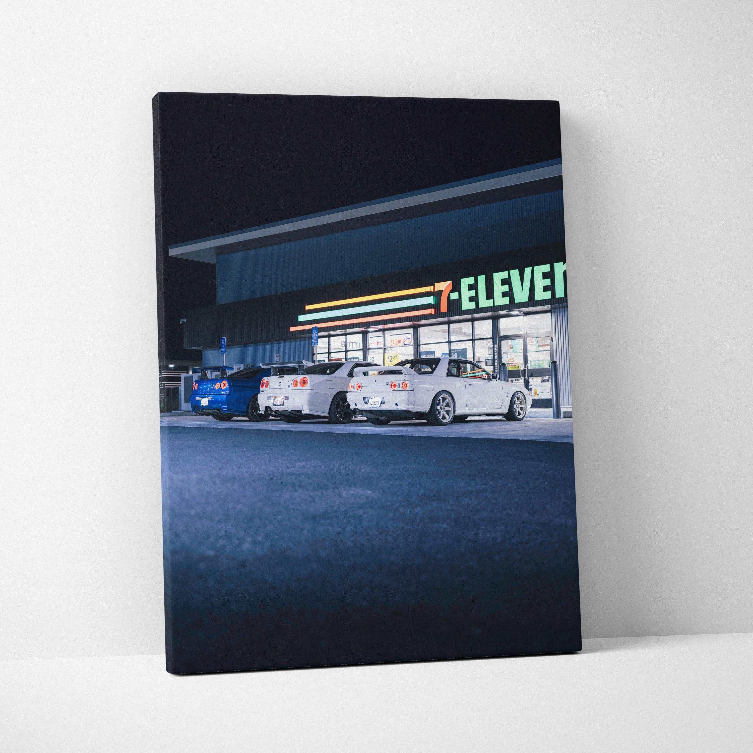 Nissan GTR R34 Skyline canvas art showing three cars parked outside a brightly lit 7-Eleven at night, vertical wall art.
