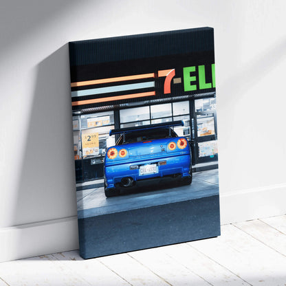 Vertical canvas wall art featuring a blue Nissan GTR R34 Skyline parked by a 7-Eleven store at dusk.