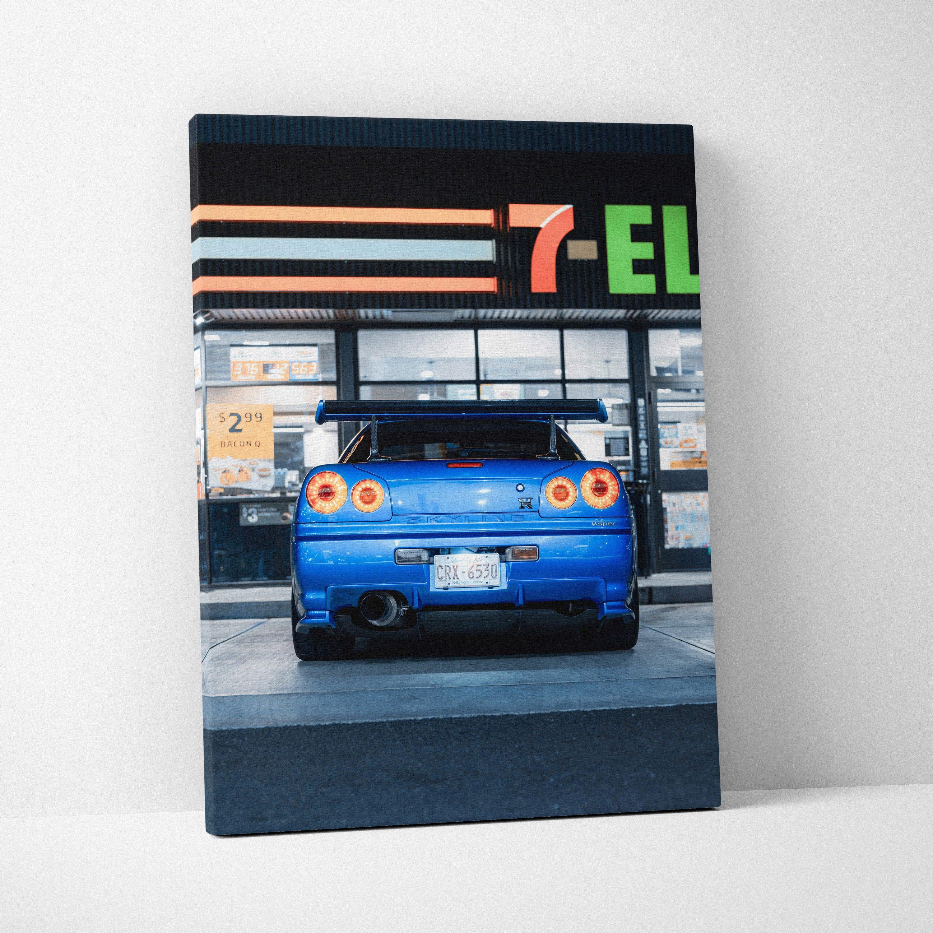 Vertical canvas wall art featuring a blue Nissan GTR R34 Skyline rear view with 7-Eleven store background.