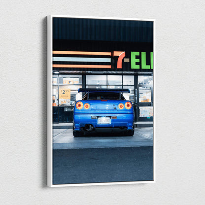 Blue Nissan GTR R34 Skyline rear view on vertical canvas wall art with urban background.