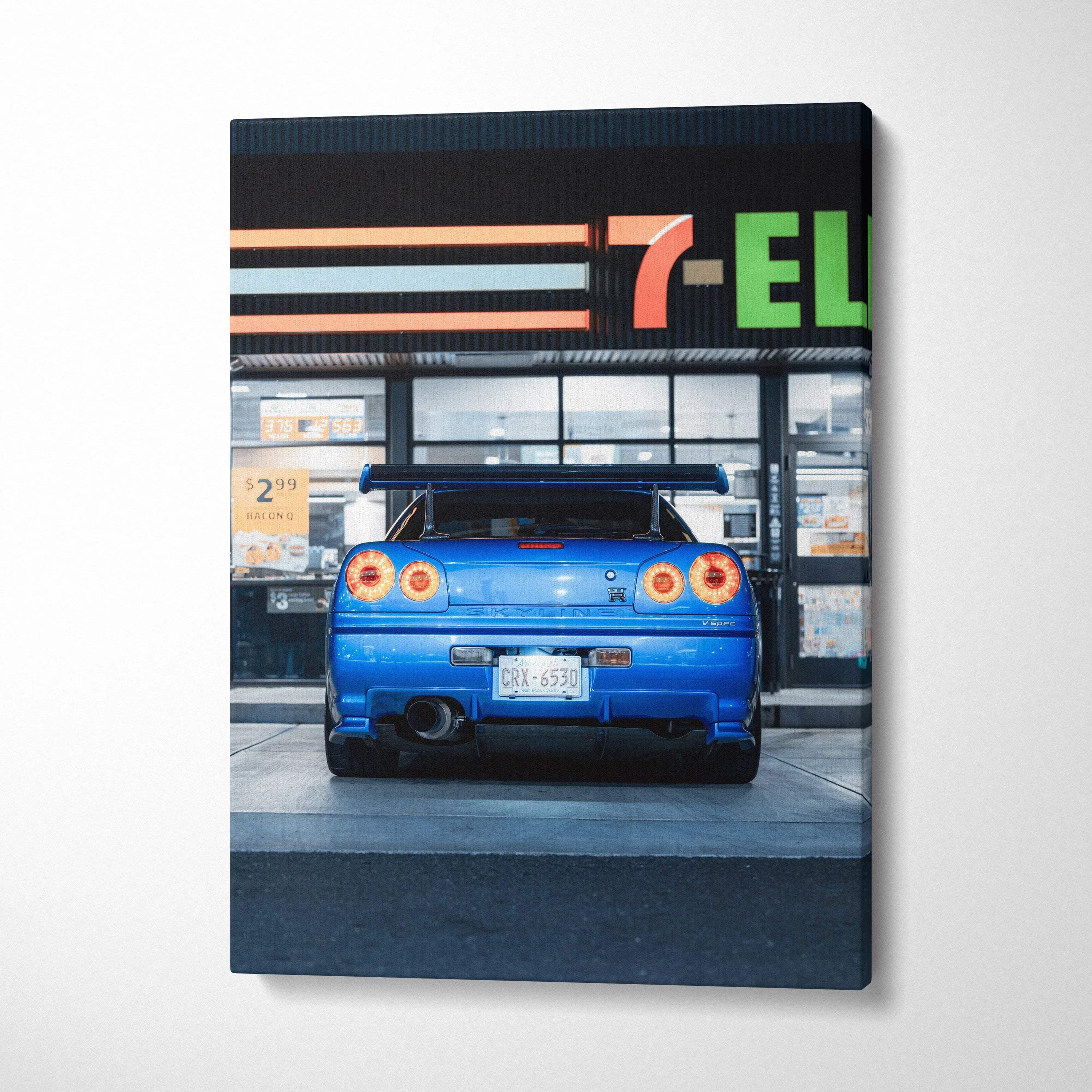 Blue Nissan GTR R34 Skyline rear view canvas art with 7-Eleven storefront wall art.
