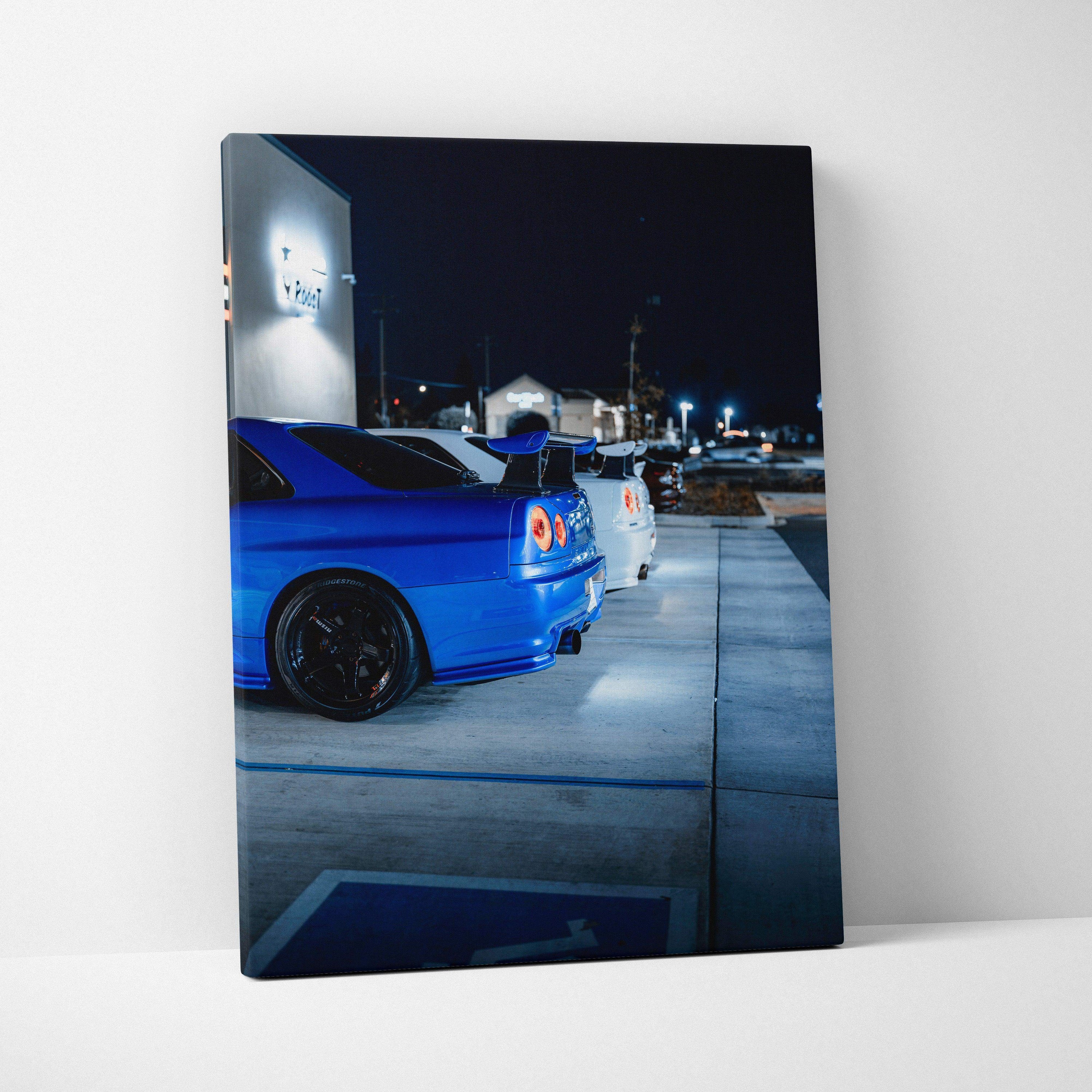 Vertical canvas art featuring a blue Nissan GTR R34 Skyline parked at night, wall art for car enthusiasts.