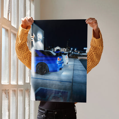 Nissan R34 GTR blue sports car poster showcasing rear view in urban night setting wall art.
