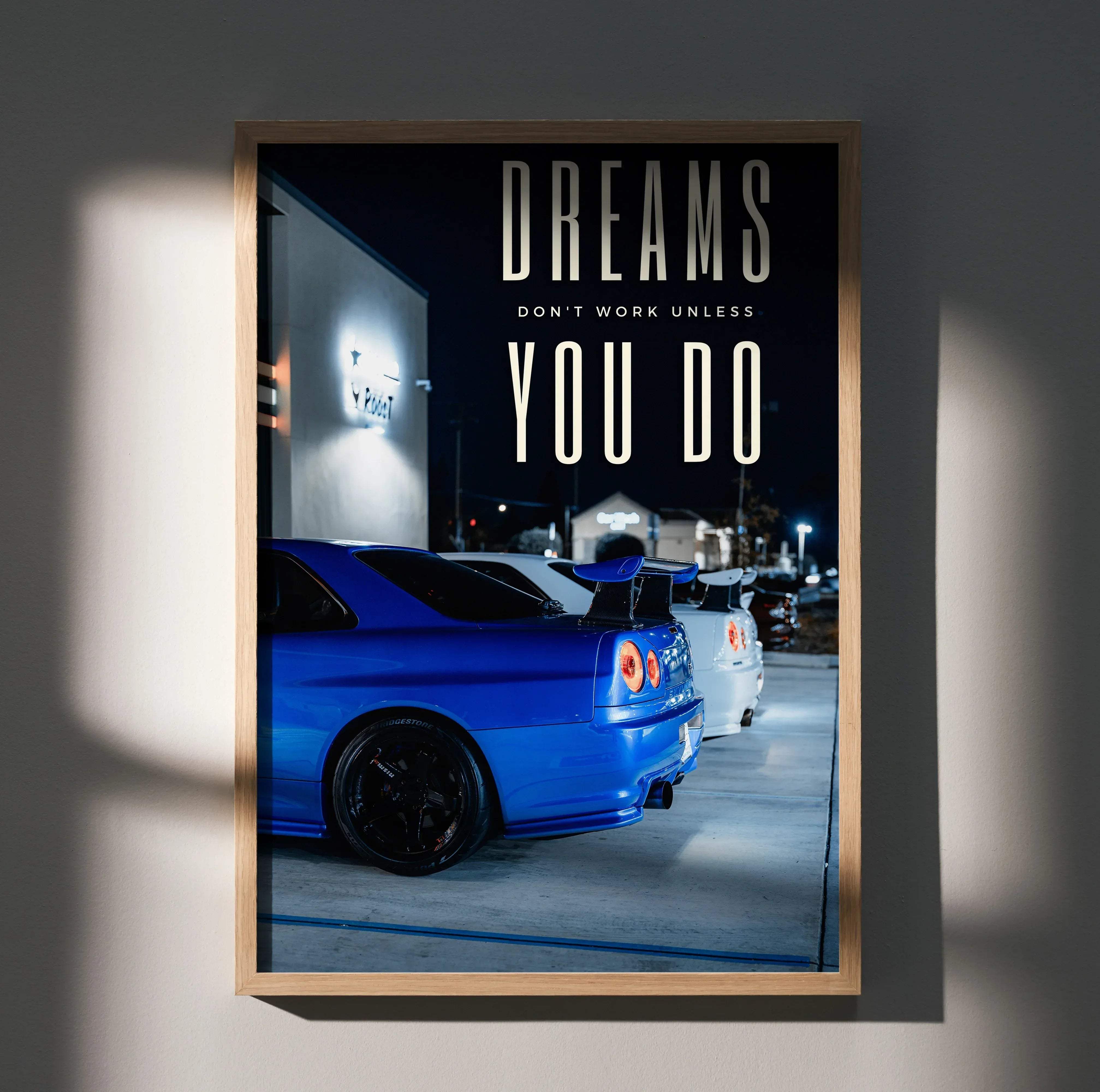 Motivational poster of a blue nissan gt-r r34 skyline sports car in a light wood frame for wall decor