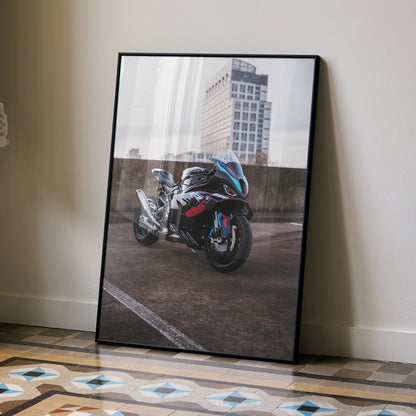 BMW M1000RR motorcycle poster wall art with urban building backdrop in sleek black frame.