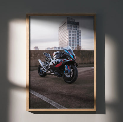 BMW M1000RR motorcycle poster wall art in urban setting with modern building background.