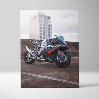 BMW M1000RR motorcycle wall art canvas featuring a sleek black and blue sportbike with red accents and cityscape background.