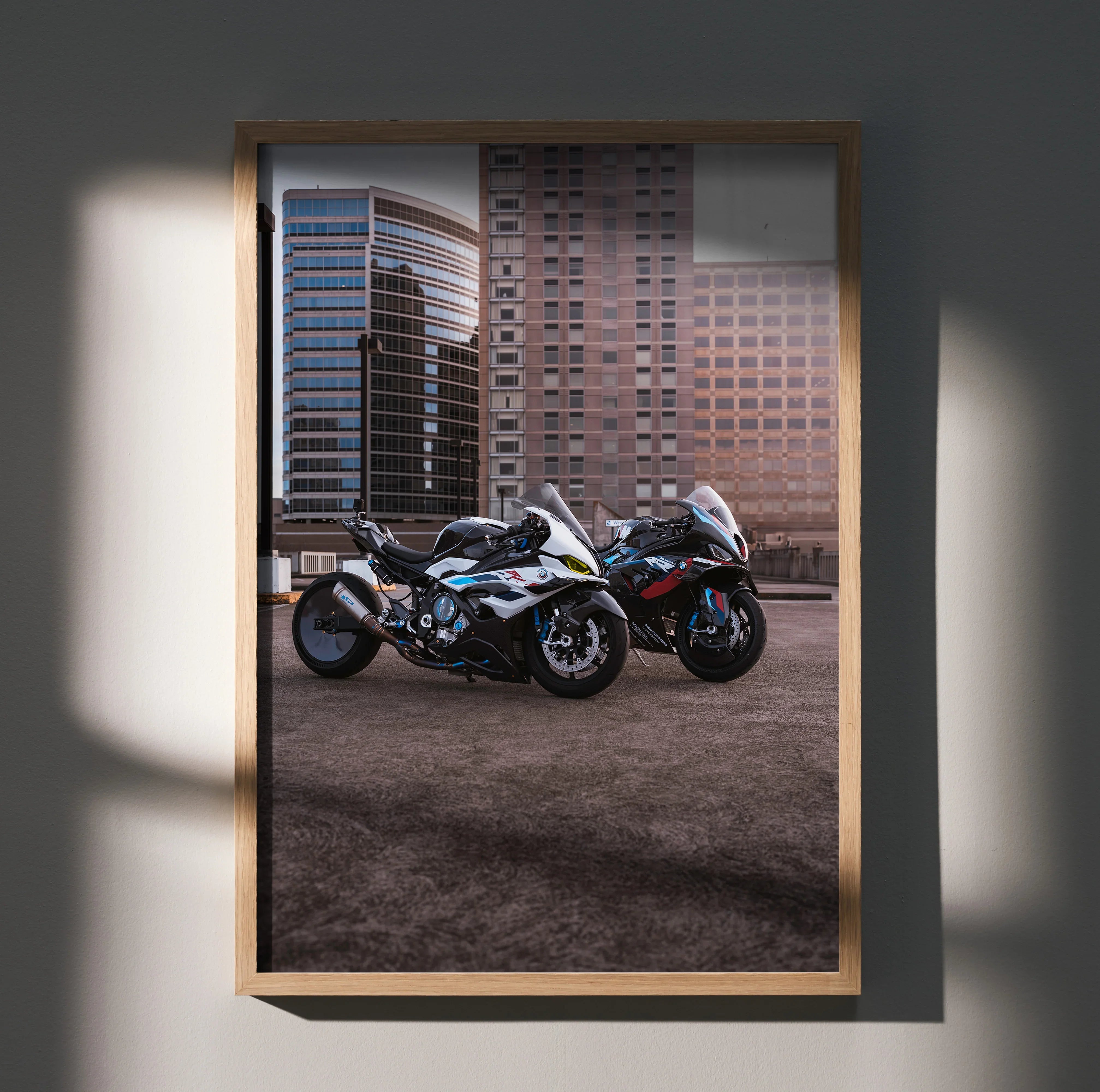 BMW M1000RR and S1000RR drag spec motorcycles poster wall art with urban backdrop in wooden frame.