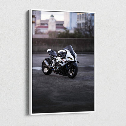 Vertical canvas art featuring a white BMW S1000RR motorcycle parked on urban pavement at dusk.
