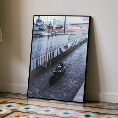 BMW S1000RR motorcycle poster leaning against wall, urban street art print on floor tiles.
