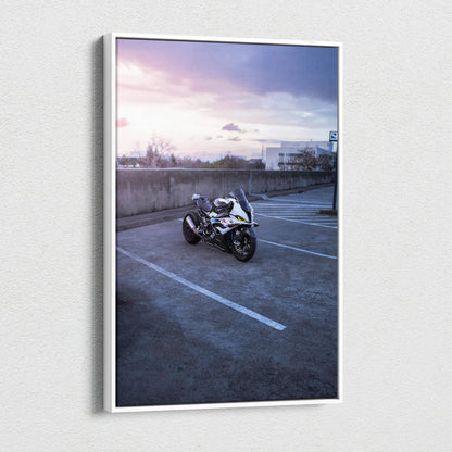 Vertical canvas wall art featuring a BMW S1000RR motorcycle in an empty parking lot at sunset.