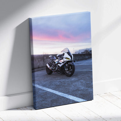 Vertical canvas wall art featuring a white BMW S1000RR motorcycle at sunset with pink and blue sky.