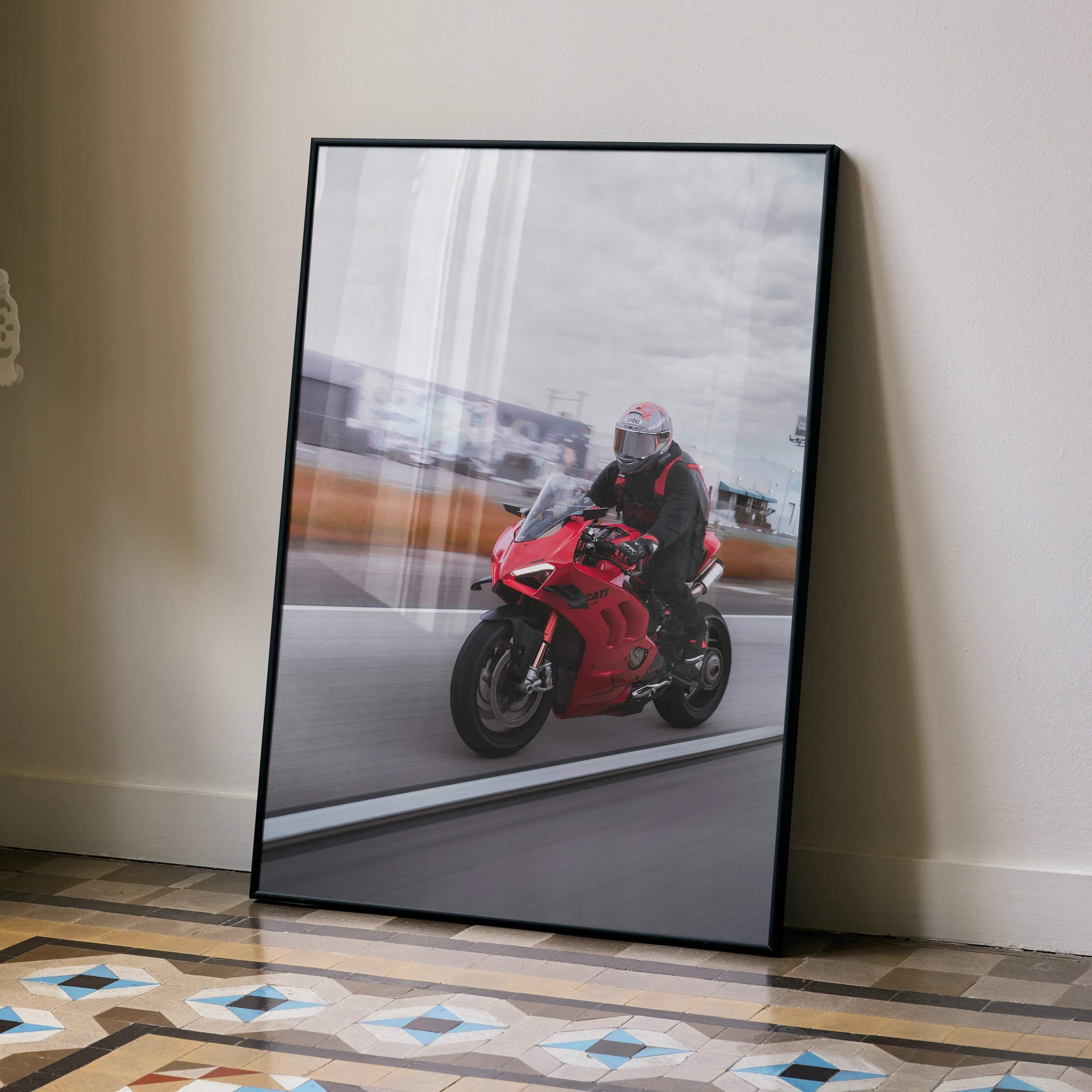 Red ducati v4s motorcycle in motion with male biker wearing shoai x-14 helmet in sleek black-framed print