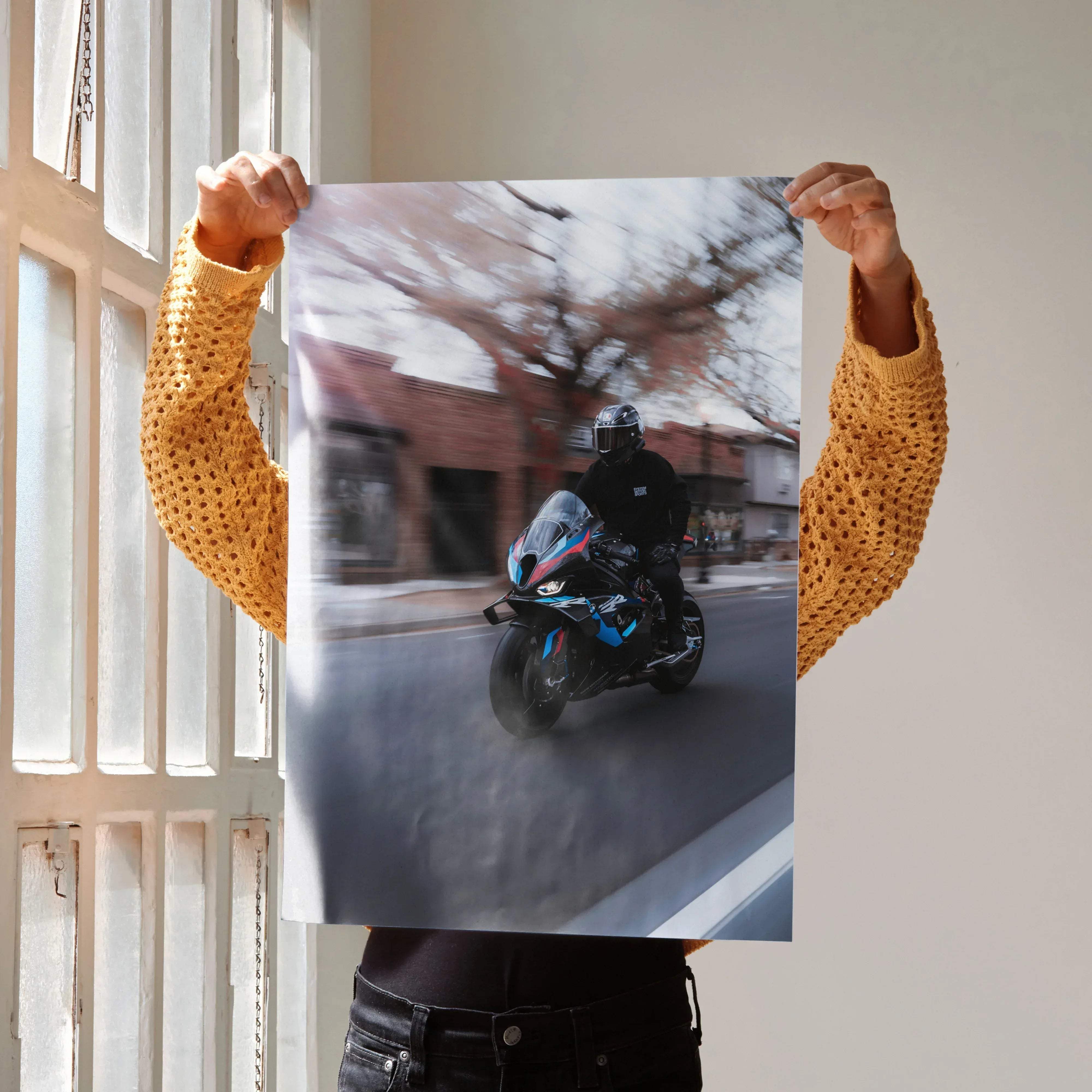 A black and blue BMW M1000RR motorcycle with AGV Pista helmet in motion captured with blurred background